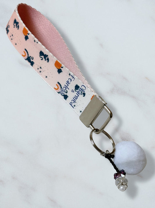 Keychain with pink ribbon and decorative elements on a light background