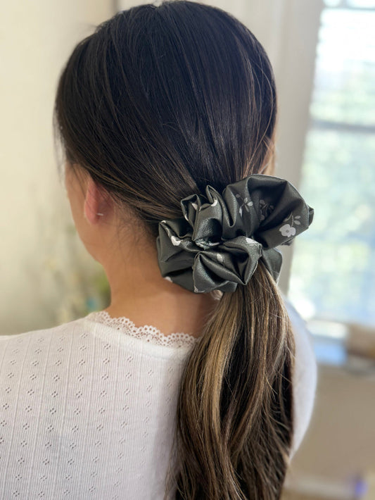 woman wearing dark olive satin floral scrunchie , designed for normal to thick and long hair, offering a secure and stylish hold.