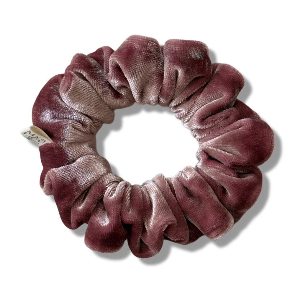 Velvet scrunchie in a gradient of pink on a white background