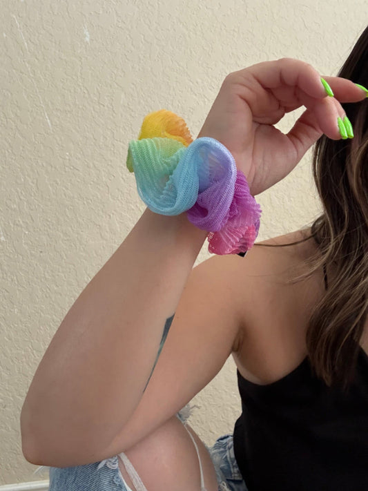 Person holding colorful scrunchies with a neutral background