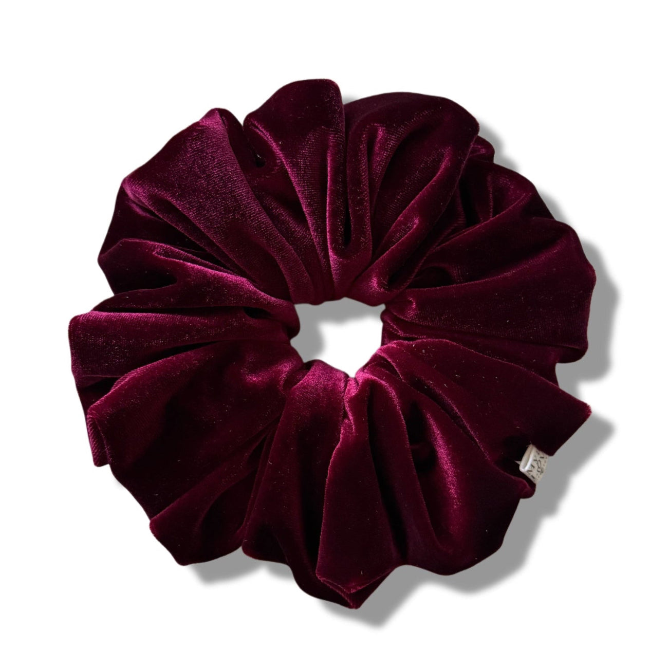 Maroon velvet scrunchie on a white background