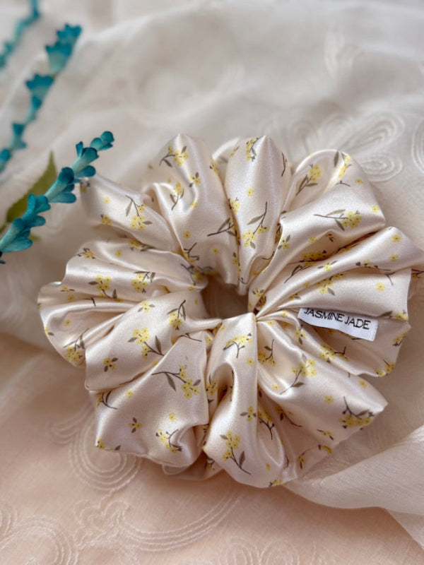 XL satin floral scrunchie in cream with delicate yellow flowers, perfect for thick and long hair, offering a secure and gentle hold.