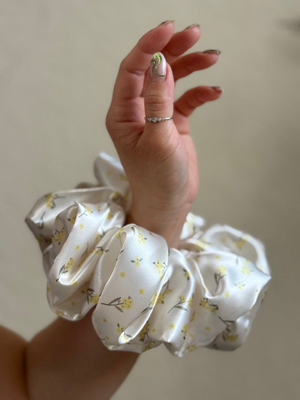 XL satin floral scrunchie in cream with delicate yellow flowers, perfect for thick and long hair, offering a secure and gentle hold.