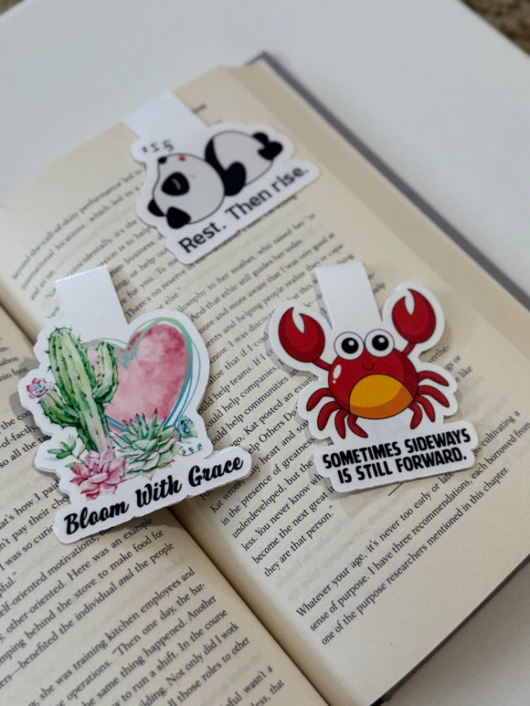 Three colorful magnetic bookmarks  on an open book with text