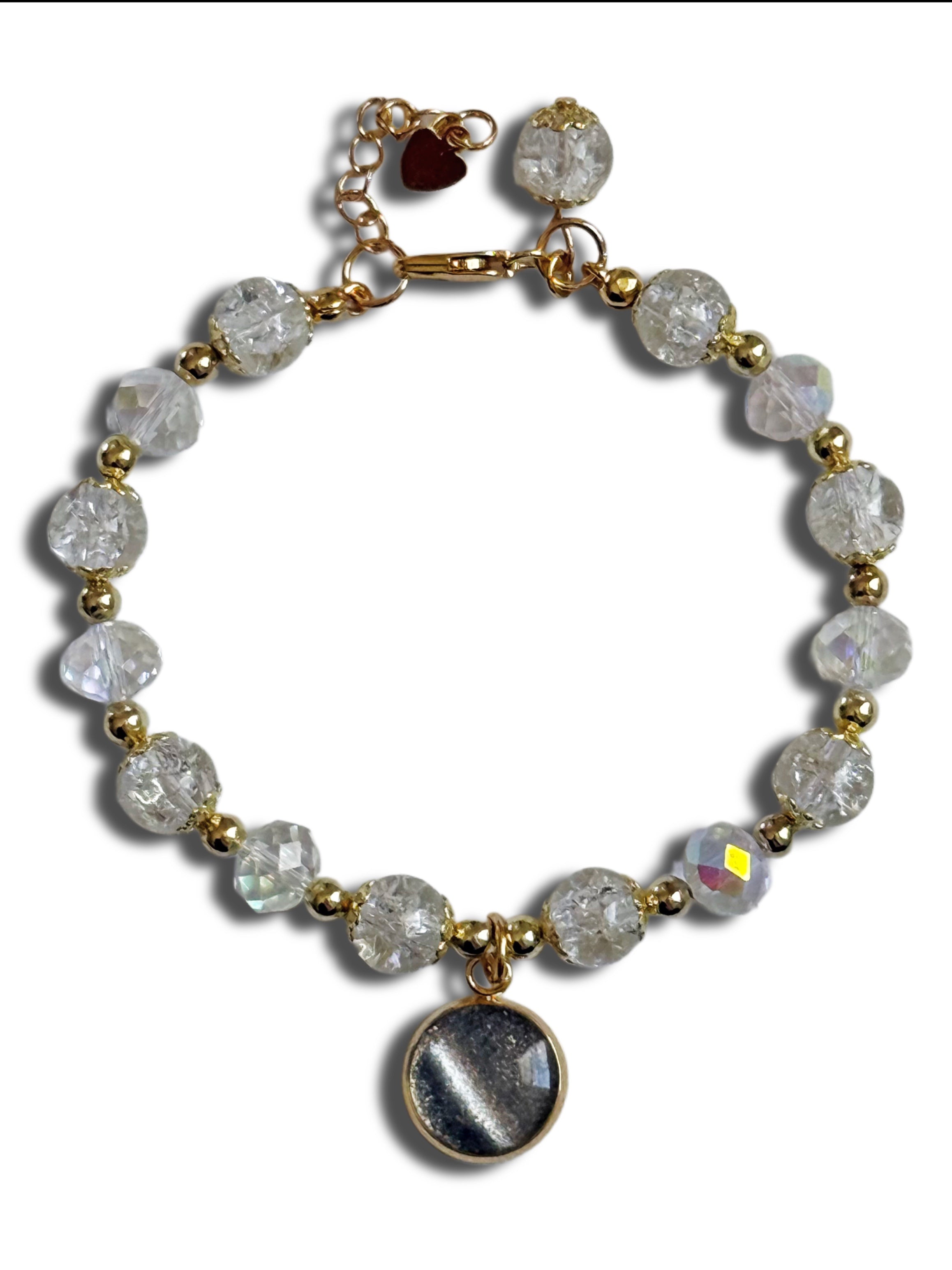 Bracelet with clear beads and a gold chain on a white background