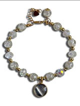 Bracelet with clear beads and a gold chain on a white background