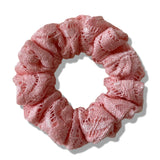 Pink lace scrunchie on a white background
