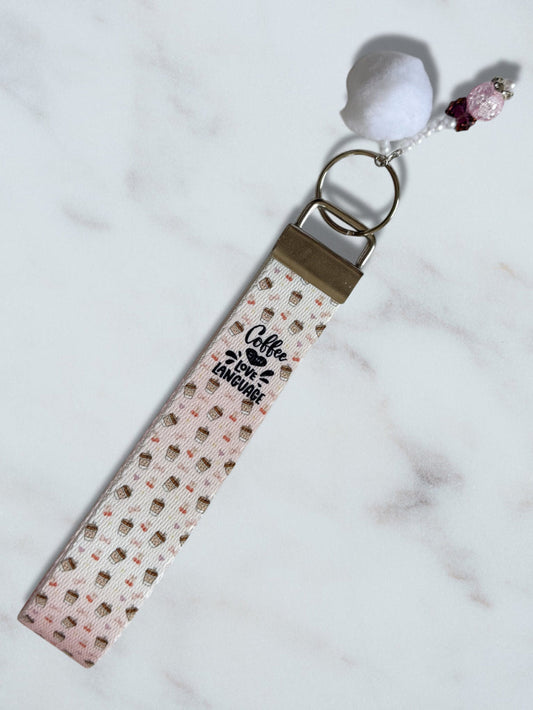 Keychain with a patterned strap and 'Coffee lover' text on a marble surface
