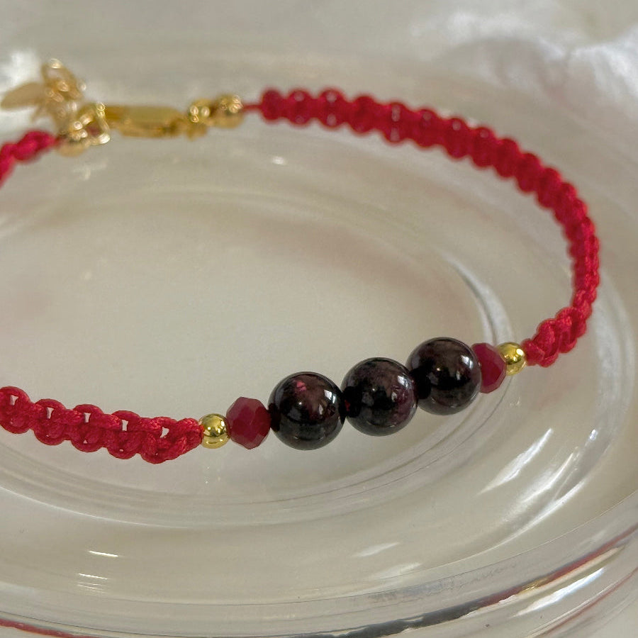 Bracelet with red and black beads on a white plate