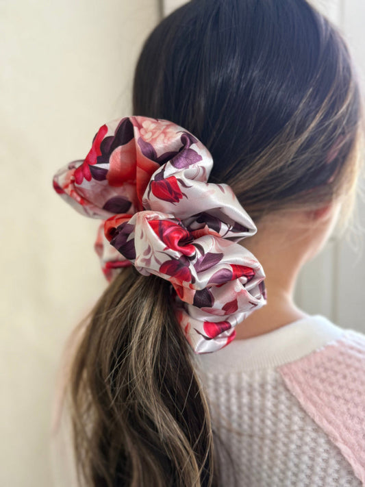 Xl satin scrunchie with a bold rose floral print in red, pink, and purple, designed for thick and long hair, offering a secure and stylish hold.
