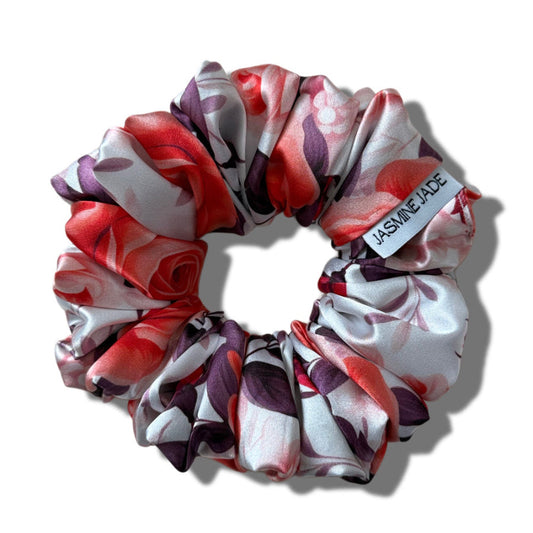 Floral patterned scrunchie with a visible brand label on a white background