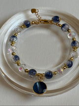 Bracelet with blue and gold beads on a white dish