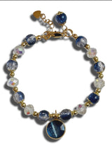 Bracelet with blue and clear beads on a white background