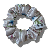 Floral scrunchie with a visible brand label on a white background