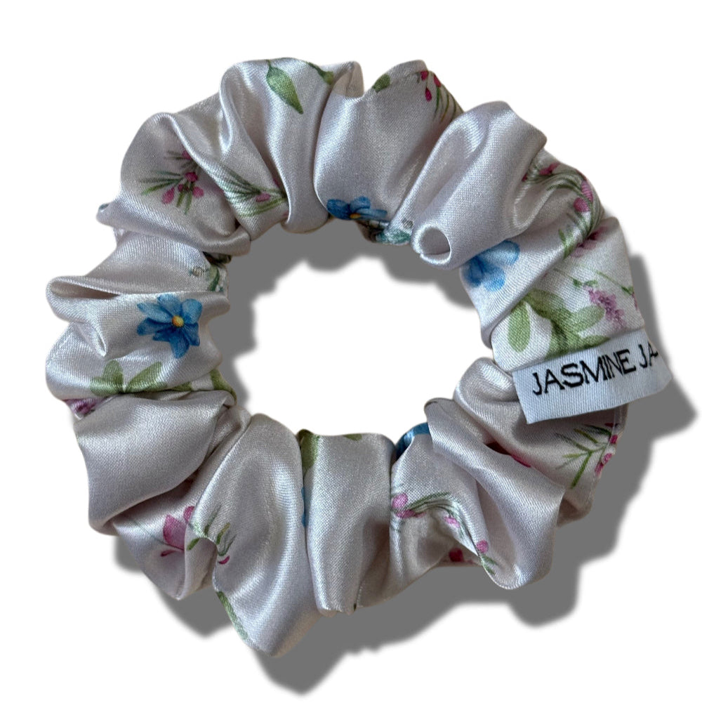 Floral scrunchie with a visible brand label on a white background