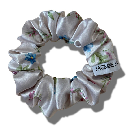 Floral scrunchie with a visible brand label on a white background
