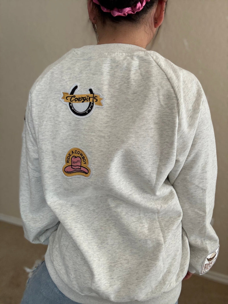 Back of cowgirl patch crewneck with horseshoe and pink cowboy hat embroidery