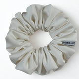 White scrunchie with a visible brand tag on a white background