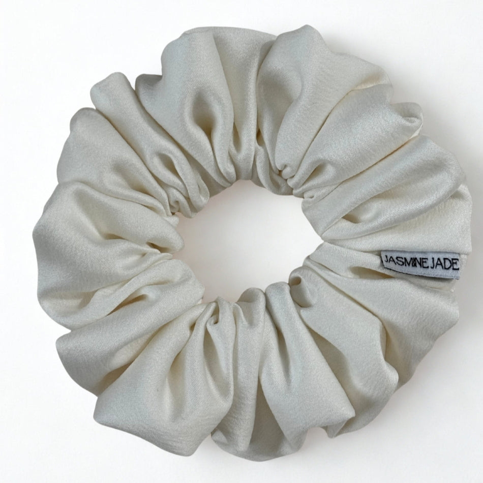 White scrunchie with a visible brand tag on a white background