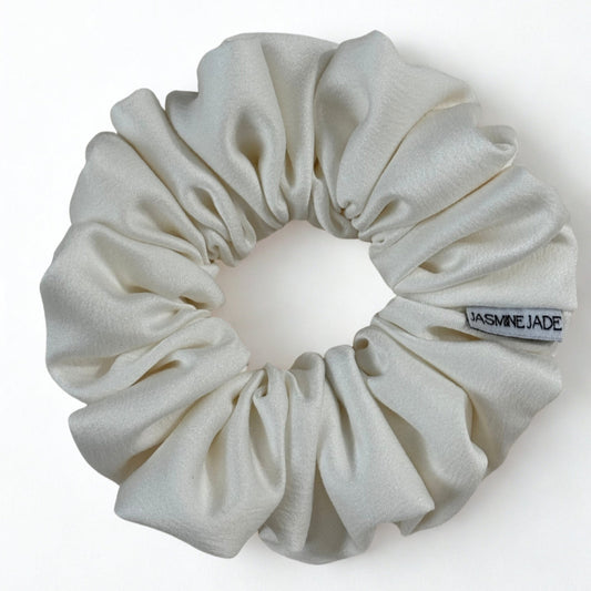 White scrunchie with a visible brand tag on a white background