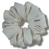 White scrunchie with a brand label on a white background
