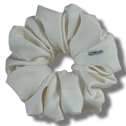 White scrunchie with a brand label on a white background