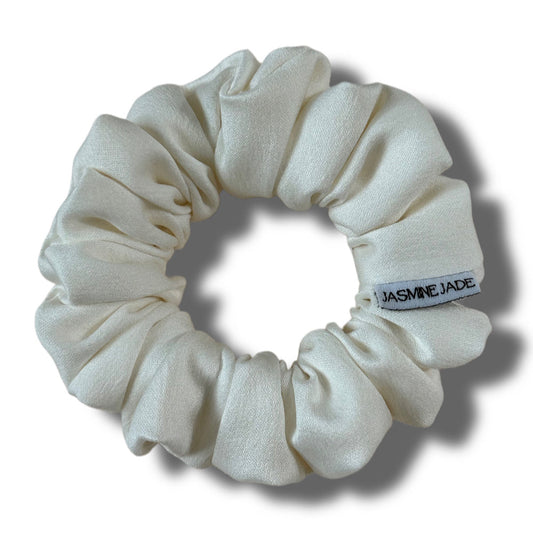 White scrunchie with a brand label on a white background