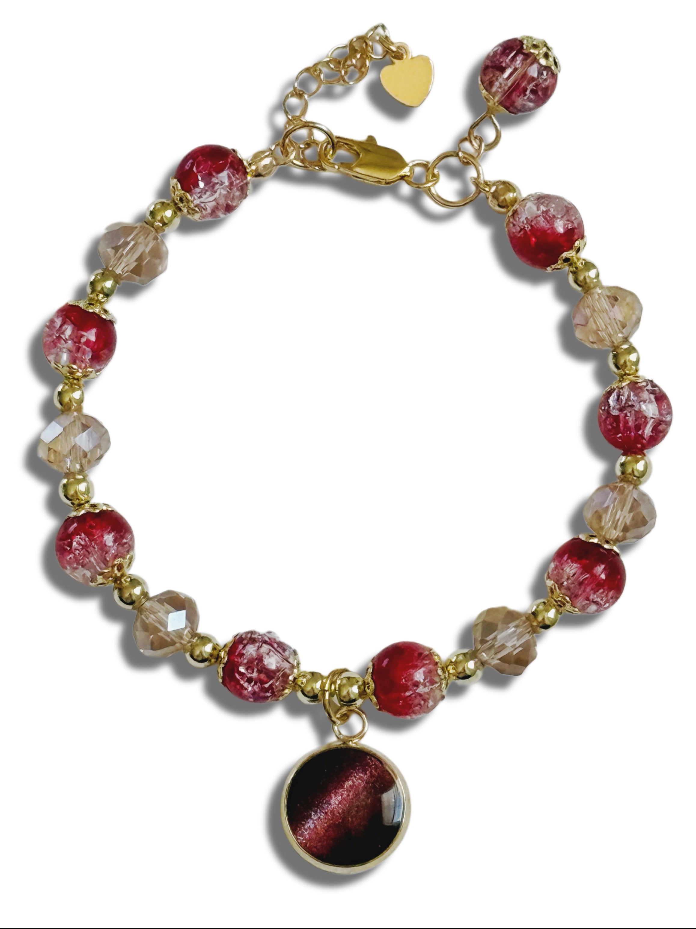 Bracelet with red and clear beads and a heart charm on a white background