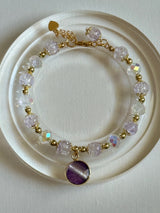 Bracelet with purple and gold beads on a white plate