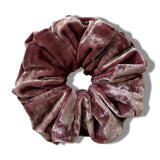 Pink velvet scrunchie on a white background