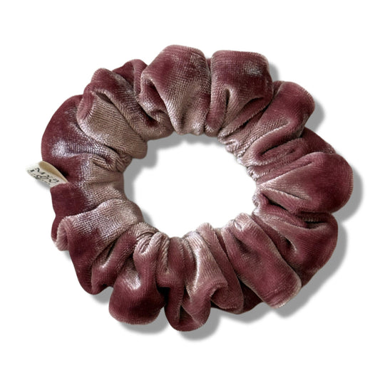 Velvet scrunchie in a gradient of pink on a white background