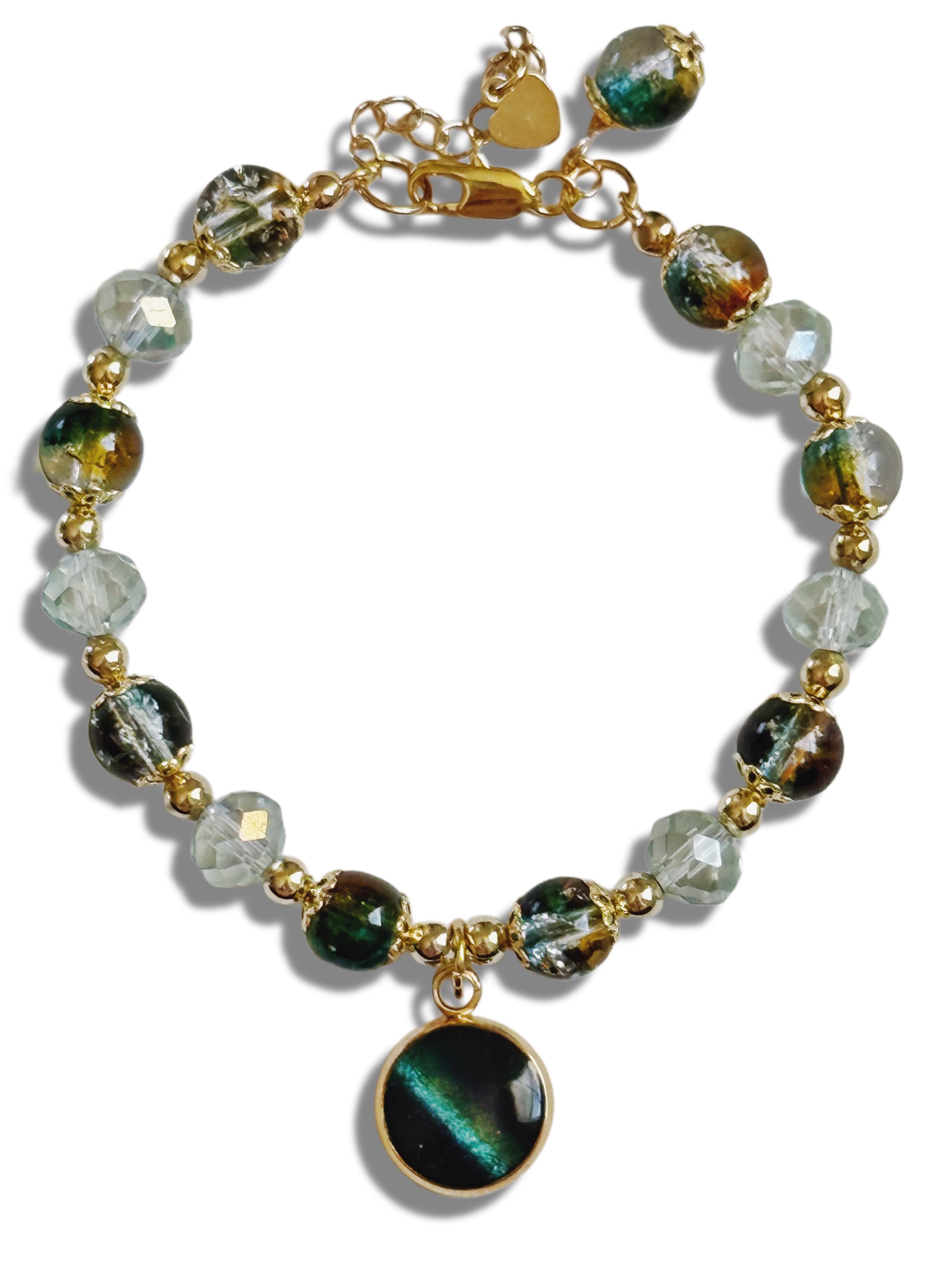 Bracelet with green and clear beads and gold accents on a white background