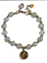 Bracelet with clear beads and gold accents on a white background