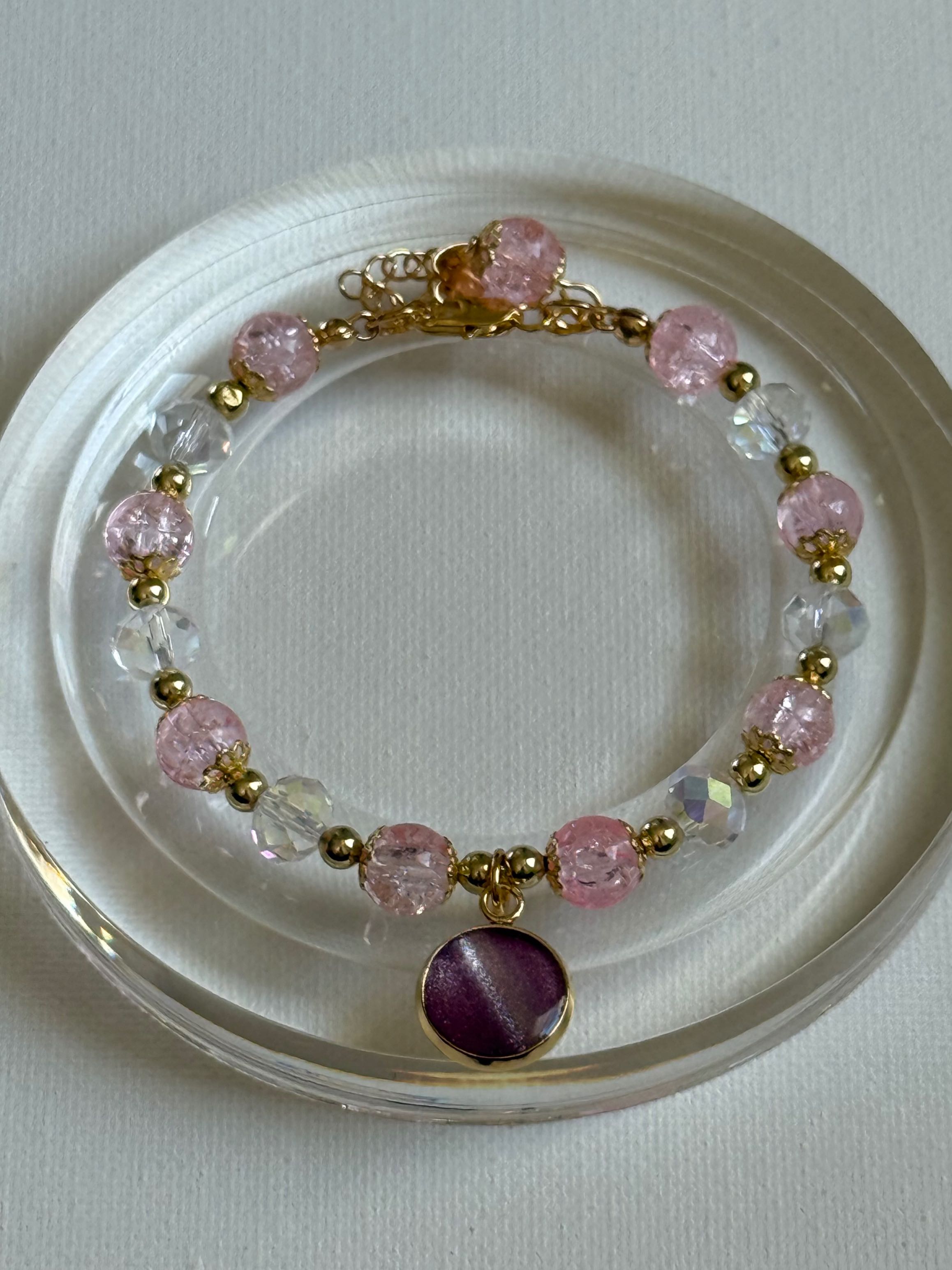 Bracelet with pink and clear beads on a white plate