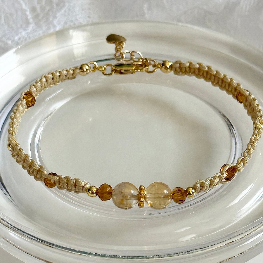 Beaded bracelet with gold and brown beads on a clear dish