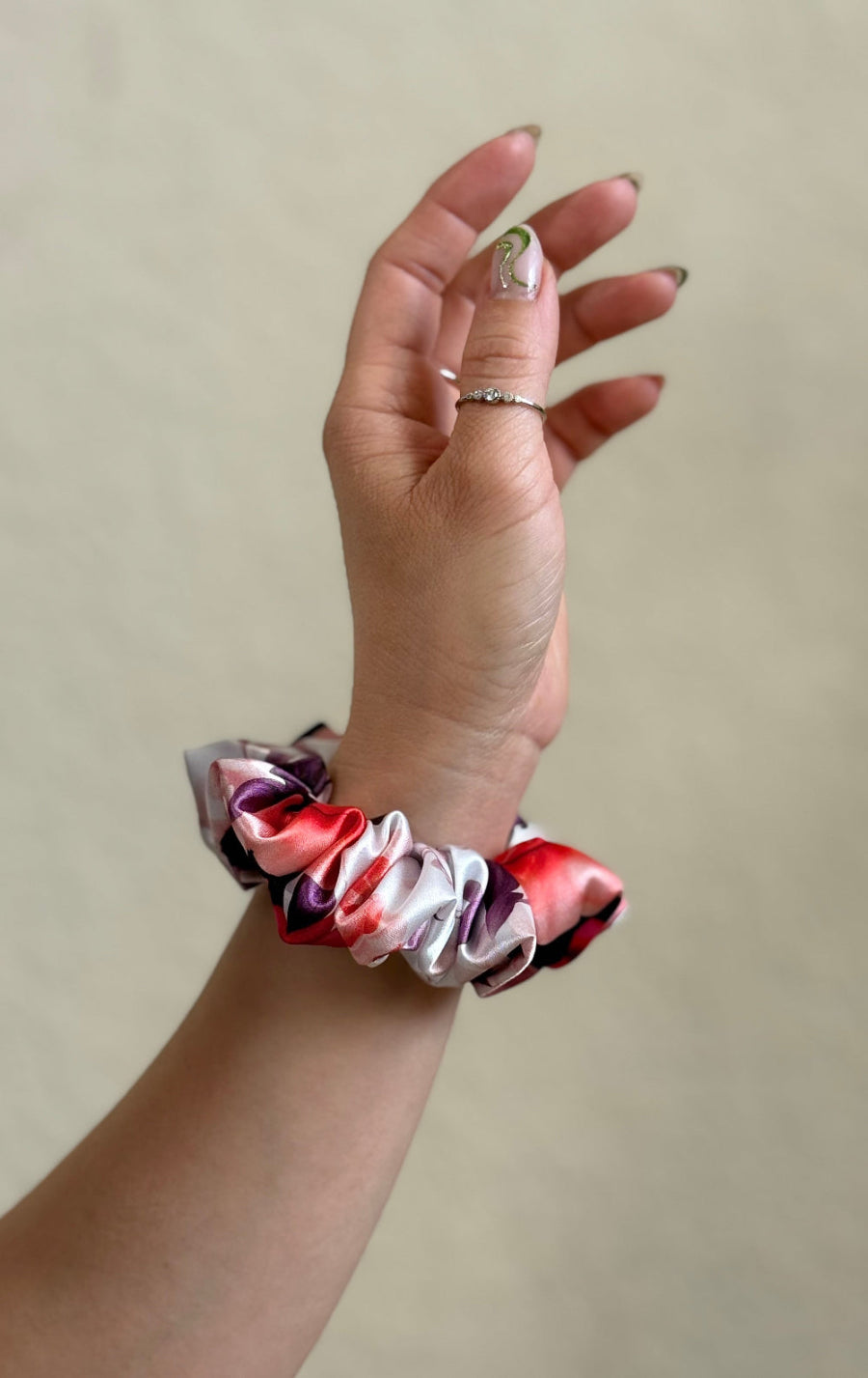 XS satin scrunchie with a bold rose floral print in red, pink, and purple, designed for everyday wear offering a secure and stylish hold.