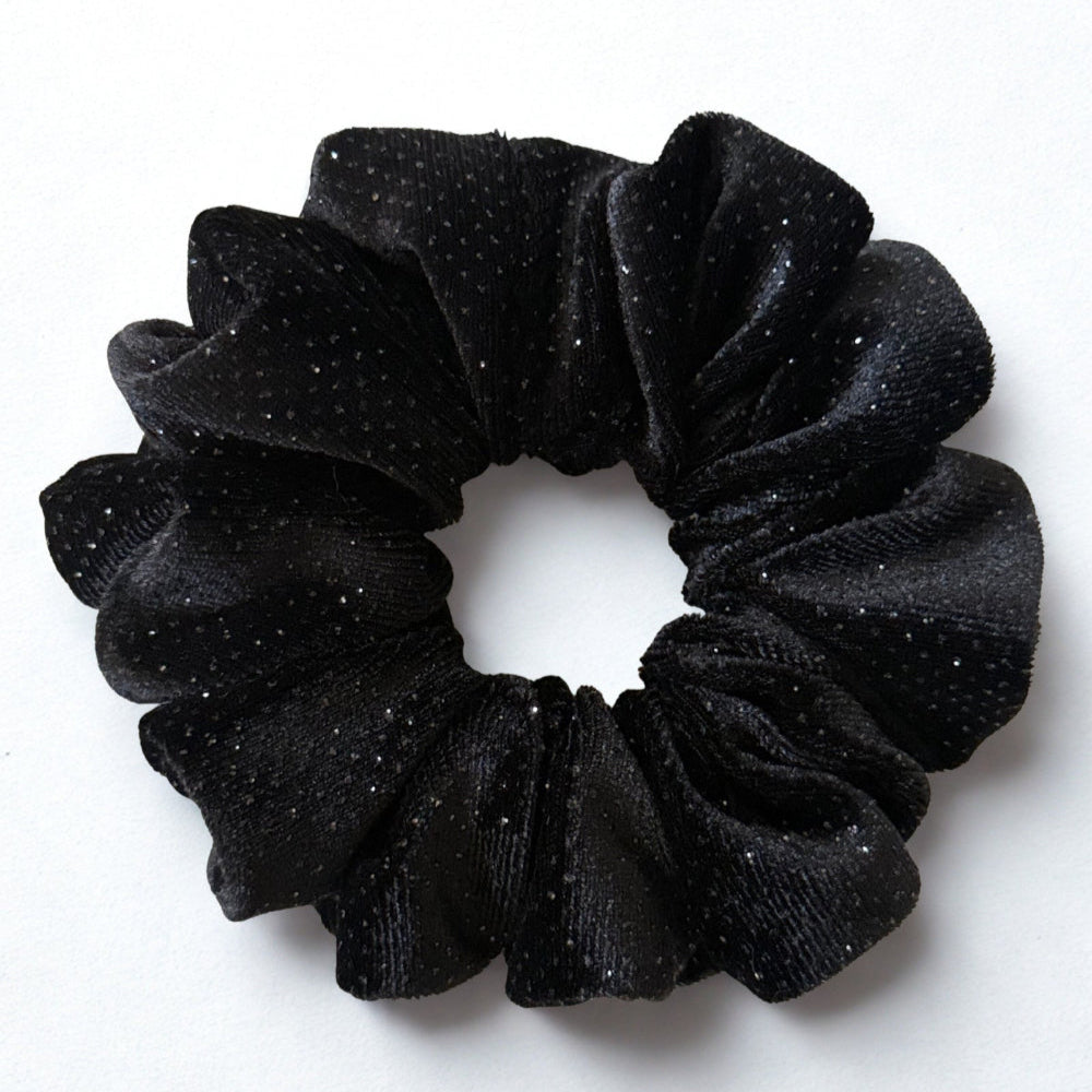 Black glittery scrunchie on a white background