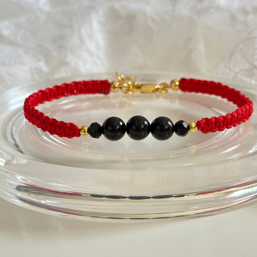 Bracelet with red and black beads on a white surface