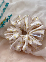 XL satin floral scrunchie in cream with delicate yellow flowers, perfect for thick and long hair, offering a secure and gentle hold.
