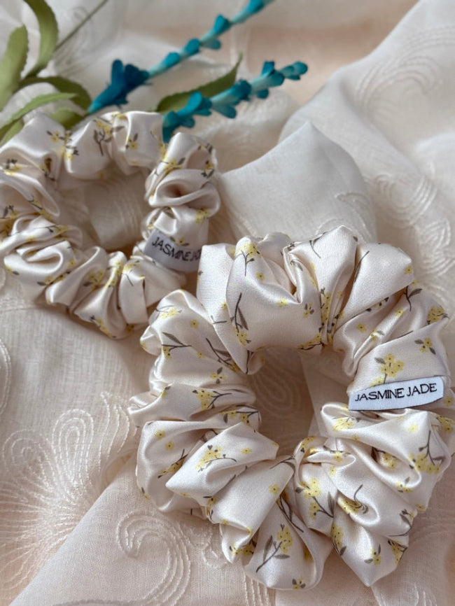  satin floral scrunchie in cream with delicate yellow flowers, perfect for normal to  thick and long hair, offering a secure and gentle hold.