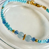 Beaded bracelet with blue and gold beads on a white dish