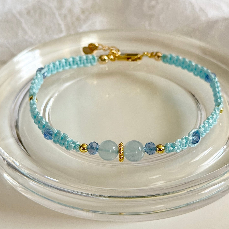 Beaded bracelet with blue and gold accents on a clear glass plate