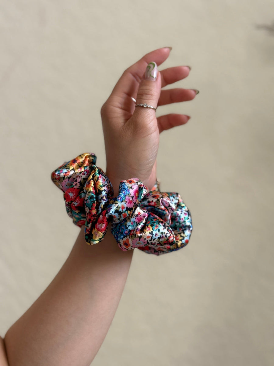 Wildflower satin floral scrunchie with a bold multicolor floral print, designed for thick and long hair, offering a secure and stylish hold.