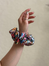 Wildflower satin floral scrunchie with a bold multicolor floral print, designed for thick and long hair, offering a secure and stylish hold.
